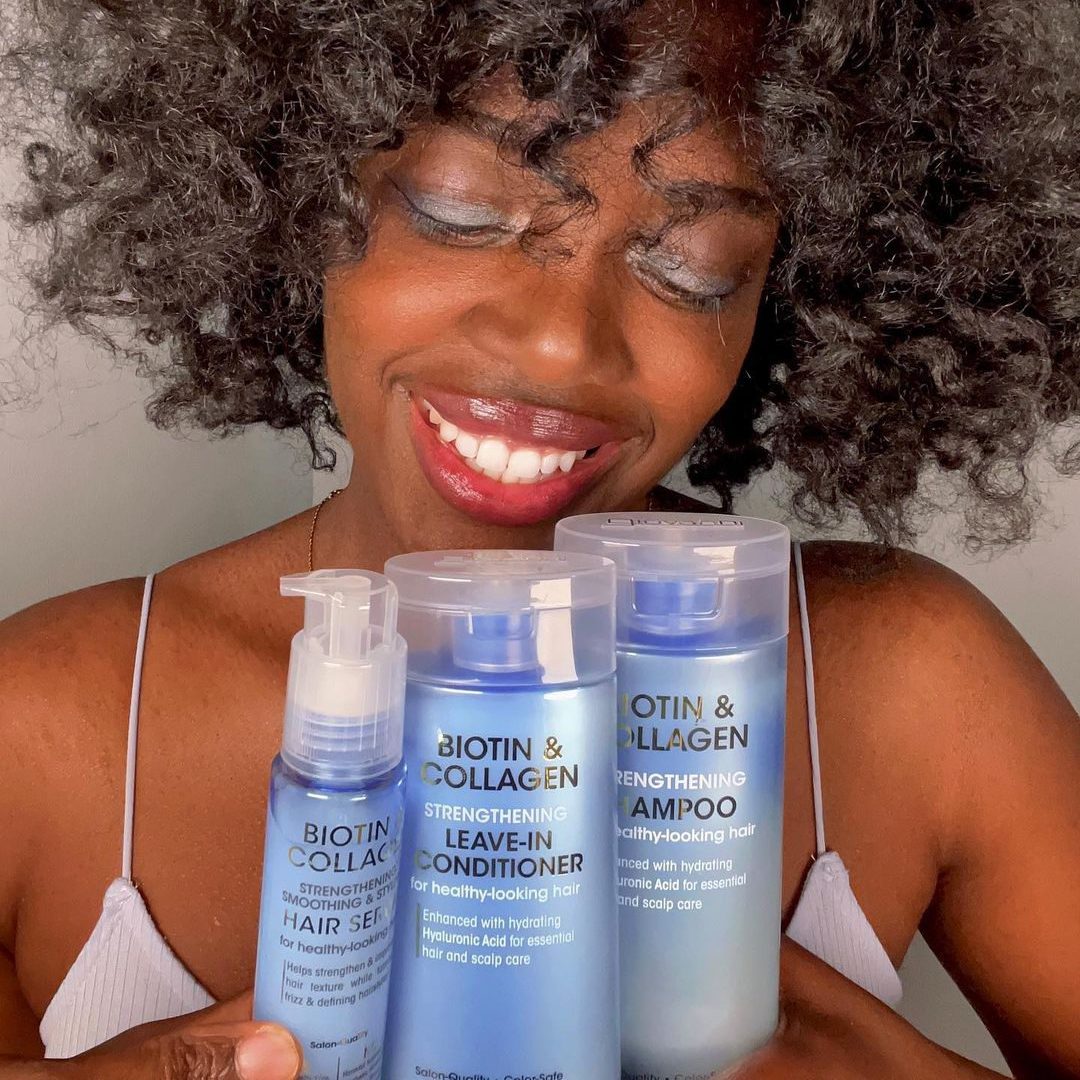 au collagène et à la biotine qui agissent ensemble pour épaissir et lisser chaque cheveu . Tr Femme souriante avec des produits capillaires en main, cheveux bouclés et peau lumineuse.