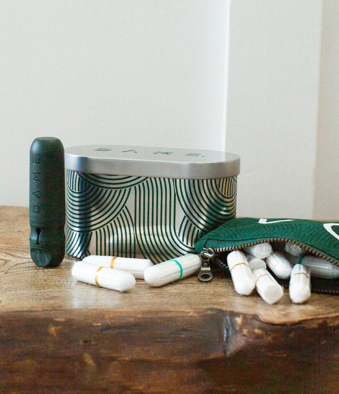 We are Dame Boîte à pilules verte avec capsules blanches et un tube vert à côté.